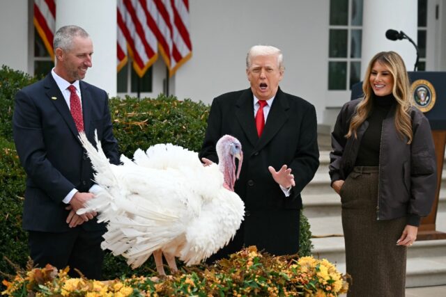 First Lady Melania Trump looks on as US President Donald Trump pardons Gobble, one of the
