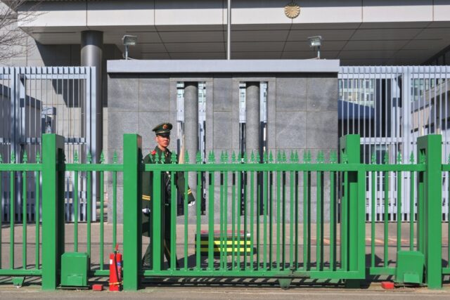 A member of security stands guard at the Japanese embassy in Beijing