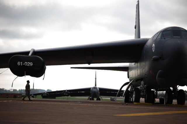 A member of a US Air Force flight crew walks under a wing of a B-52 Stratofortress bomber