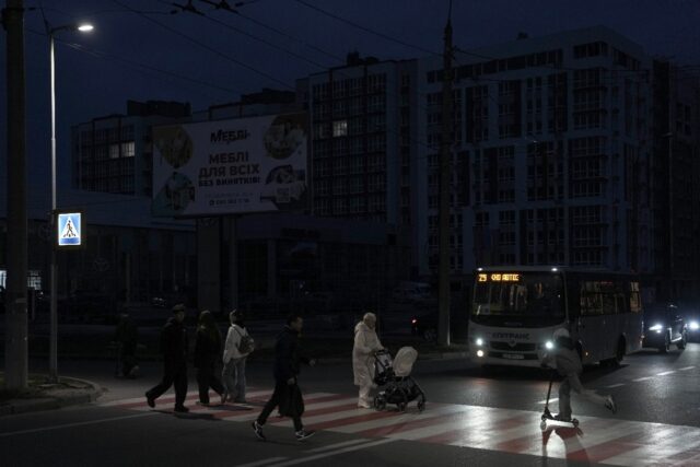 Pedestrians cross a street without lights in Chernigiv on October 22, 2025, following a re