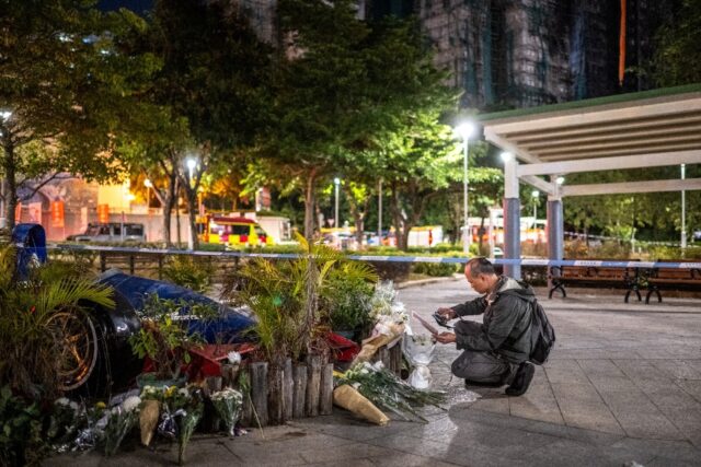 People have left flowers and cards of remembrance near Wang Fuk Court, the site of the dea