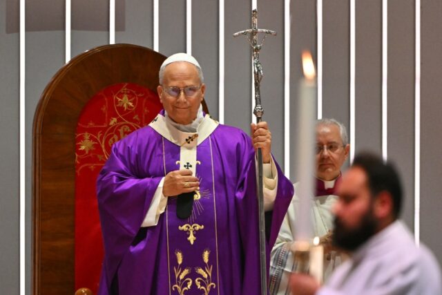 As Pope Leo entered, many worshippers rose to their feet