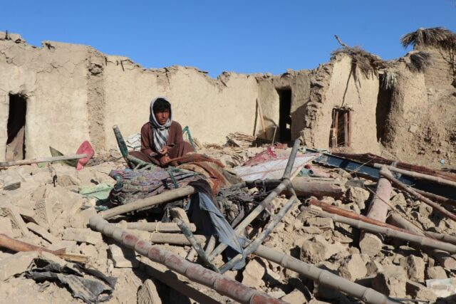 A resident sits at a damaged house after an air strike Afghanistan's Taliban governme