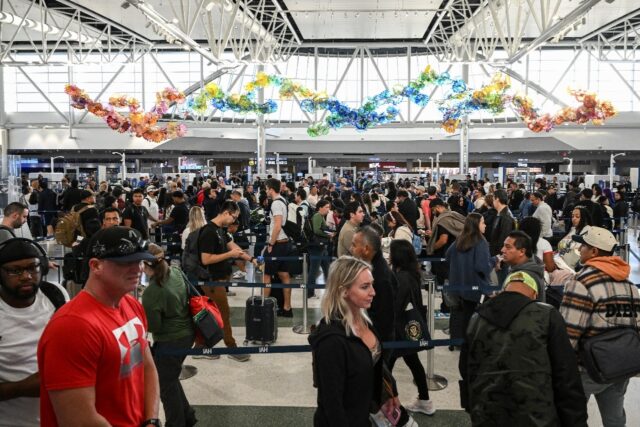 Travelers wait in line at a security checkpoint at George Bush Intercontinental Airport in