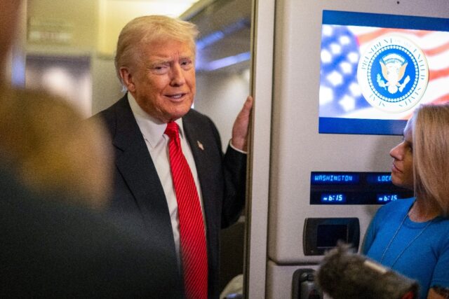 US President Donald Trump speaks to members of the press aboard Air Force One on November
