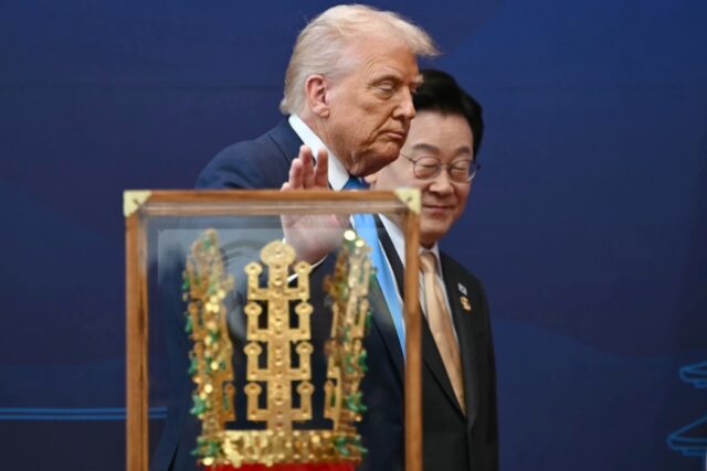 US President Donald Trump walks with South Korean President Lee Jae Myung during a ceremon