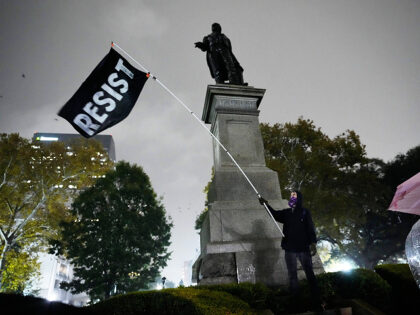 AP25336025740988 (1) A protester waves a flag in a pouring rain during a demonstration against an impending Cus