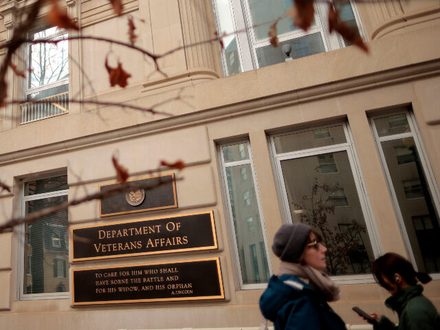 People walk past the Department of Veterans Affairs headquarters a block from the White Ho