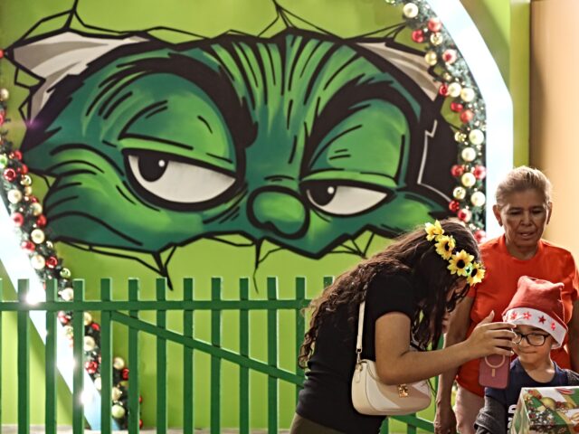 SAN SALVADOR, EL SALVADOR - DECEMBER 23: Women giving a gift to a child in front of the Gr