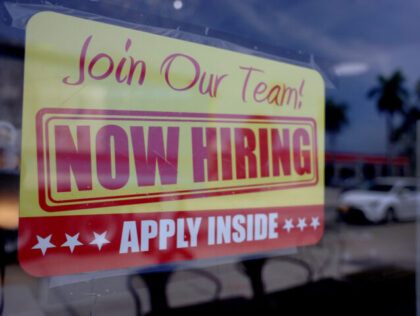 MIAMI, FLORIDA - MAY 05: A 'Now Hiring' sign posted in the window of a restauran