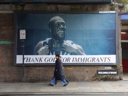 TOPSHOT - Pedestrians walk past a billboard featuring an image of British rapper Stormzy w