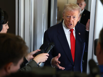 U.S. President Donald Trump speaks to members of the media on board Air Force One on Octob