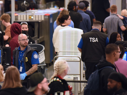 ORLANDO, FLORIDA, UNITED STATES - NOVEMBER 26: Travelers move through a TSA security scree