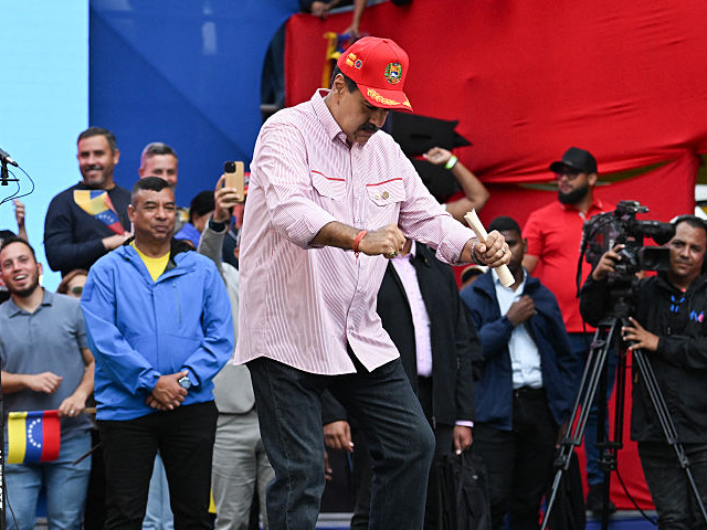 Venezuela's President Nicolas Maduro dances during a rally in Caracas on December 1, 2025.