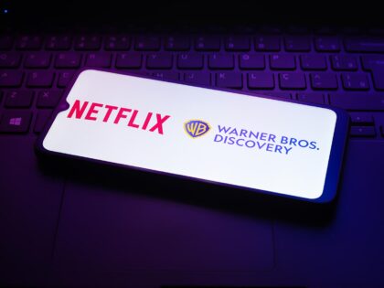 The Netflix and Warner Bros. Discovery app logo appears on the screen of a smartphone in R