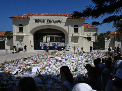 SYDNEY, AUSTRALIA - DECEMBER 17: People gather at a flower memorial beside Bondi Pavilion