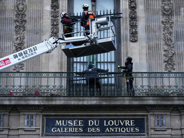 Workers install iron window guards on the window of the Gallerie d'Apollon (Apollo's galle