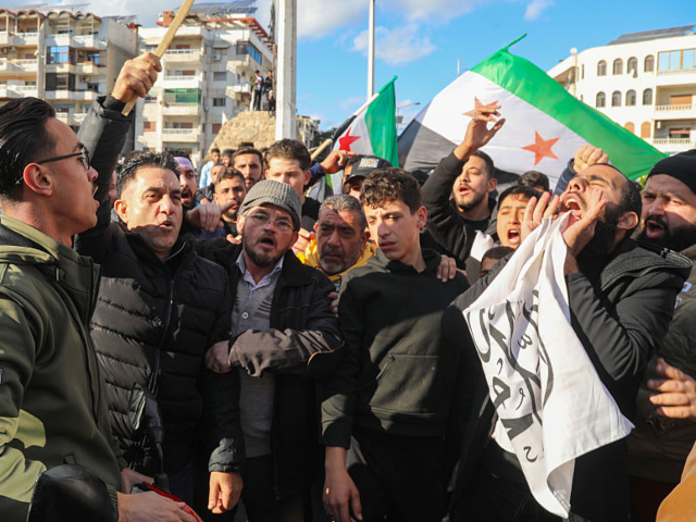 LATAKIA, SYRIA - DECEMBER 28: Demonstrators hold placards targeting Damascus administratio