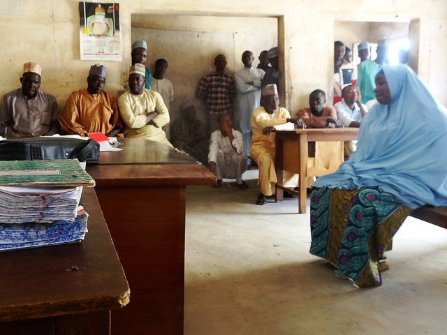 A veiled muslim woman sits before Islamic judge Nuhu Mohammed Dumi during a court trial ov