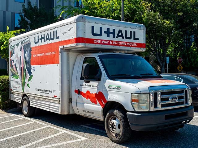 GettyImages2165443151 Moving truck parked in a shaded lot on a sunny day, with U-Haul branding, San Jose, Califo
