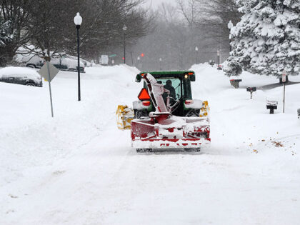 A snow removal machine makes its way along Nettle Creek Road after over two feet of heavy