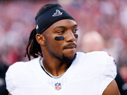 Bijan Robinson #7 of the Atlanta Falcons stands on the sidelines during the national anthe