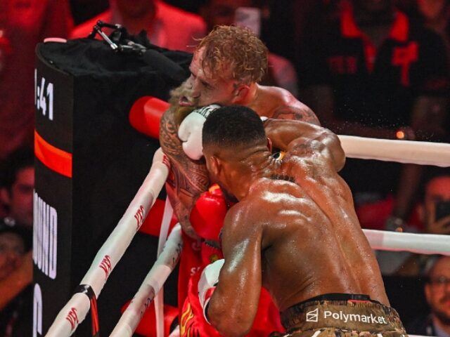 US boxer and influencer Jake Paul gets hit by British boxer Anthony Joshua (R) in a non-ti