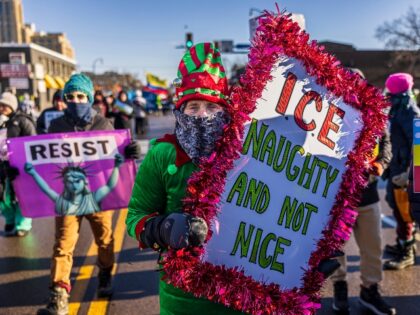 A protester holds an sign as she marches through frigid conditions, with temperatures near