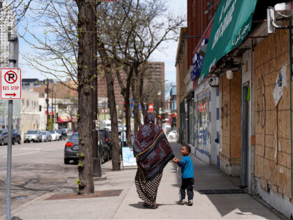 FILE - A woman and a child hold hands as they walk down a street in the predominantly Soma