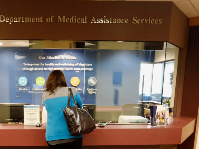 A visitor checks in at the front desk of the Virginia Department of Medical Assistance Ser