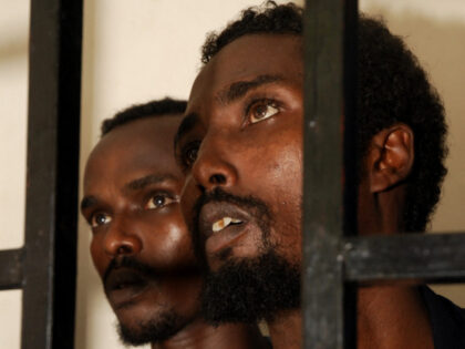 Suspected Somali pirates sit behind bars during the first hearing in their trial at Aden p