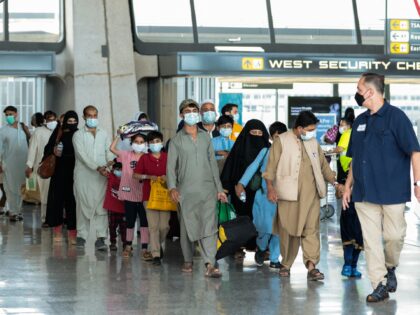 DULLES, VIRGINIA - AUGUST 31: Refugees walk through the departure terminal to a bus at Dul