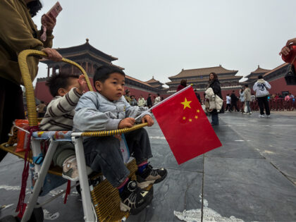 BEIJING, CHINA - NOVEMBER 6: A child holding a Chinese national flag sits in a stroller as