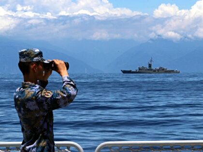 A soldier looks through binoculars during combat exercises and training of the navy of the