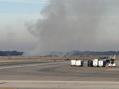 This picture provided by Houman David Hemmati shows smoke billowing on a runway at Dulles