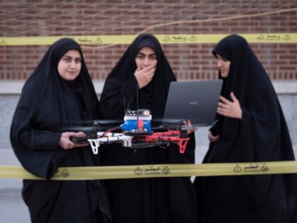 A smart drone flies as veiled Iranian drone specialists control it ahead of a competition