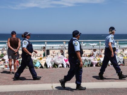 nsw police make stop The Police walk past floral tributes left at the promenade of Bondi Beach in Sydney on Dec