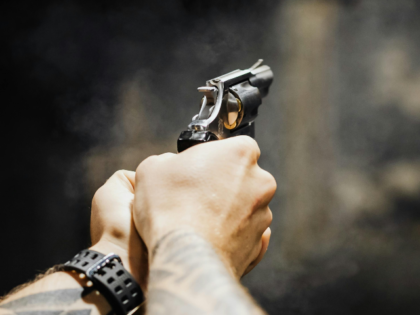 A Person Holding Black and Silver Revolver Pistol