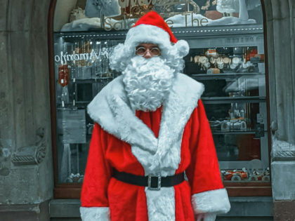 Santa Clause Standing in the City Street at Christmas Time