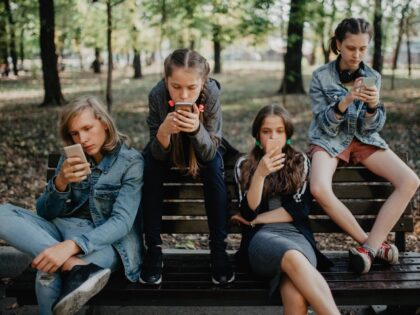 Teenagers in the public park using smartphones