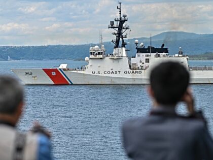 Members of the media look out at the United States Coast Guard ship 'Cutter Stratton' duri