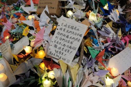 Mourners left paper cranes and candles at a vigil held outside the Wang Fuk Court apartmen