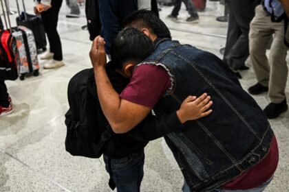 Osvaldo (R) caregiver of six-year-old US citizen Andy (L) hugs him as the boy prepares to