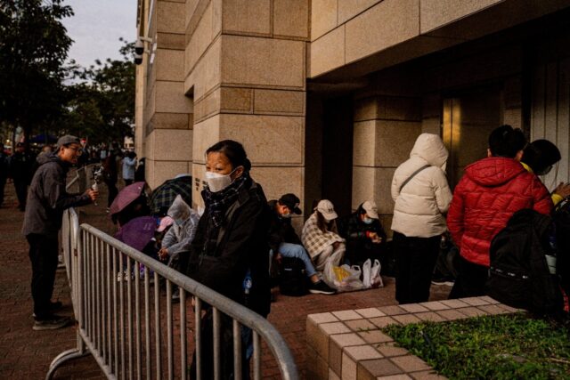 People wait in line outside the West Kowloon Law Courts building to hear the verdict in th