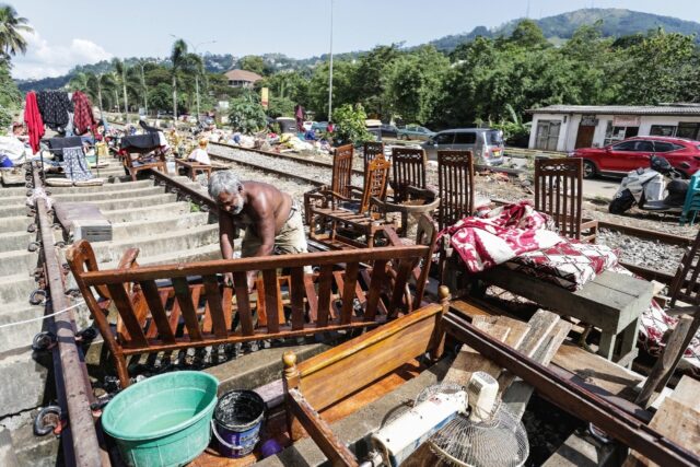 A Sri Lankan flood victim sorts out his belongings by railway tracks in Kandy. The authori