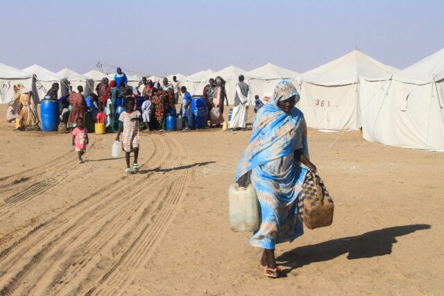 Sudanese who fled massacres and sexual violence in El-Fasher in Darfur carries jerrycans h