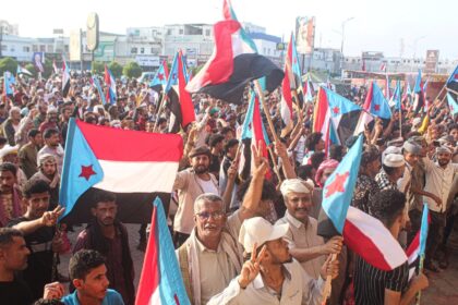 Supporters of the UAE-backed Southern Transitional Council wave flags of South Yemen, whic