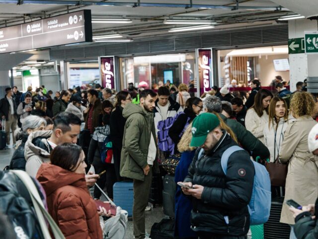 Passengers wait in the hall of Madrid train station on Sunday, January 18, 2026, following
