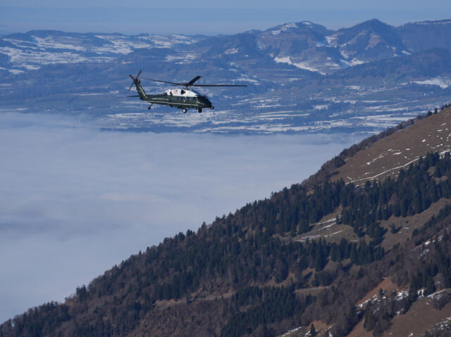 Marine One, carrying President Donald Trump, flies over snow covered mountains during his