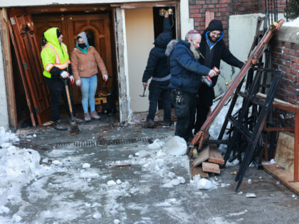 Workers repair a door outside of the Chabad Lubavitch world headquarters, where a man was